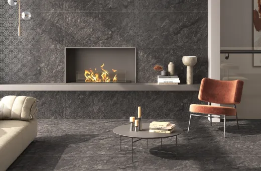 A living room with a fireplace wall and floor in dark Letoza stone-look tiles