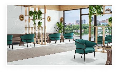 A lounge finished in Letoza tiles, with green armchairs and a view over the lake
